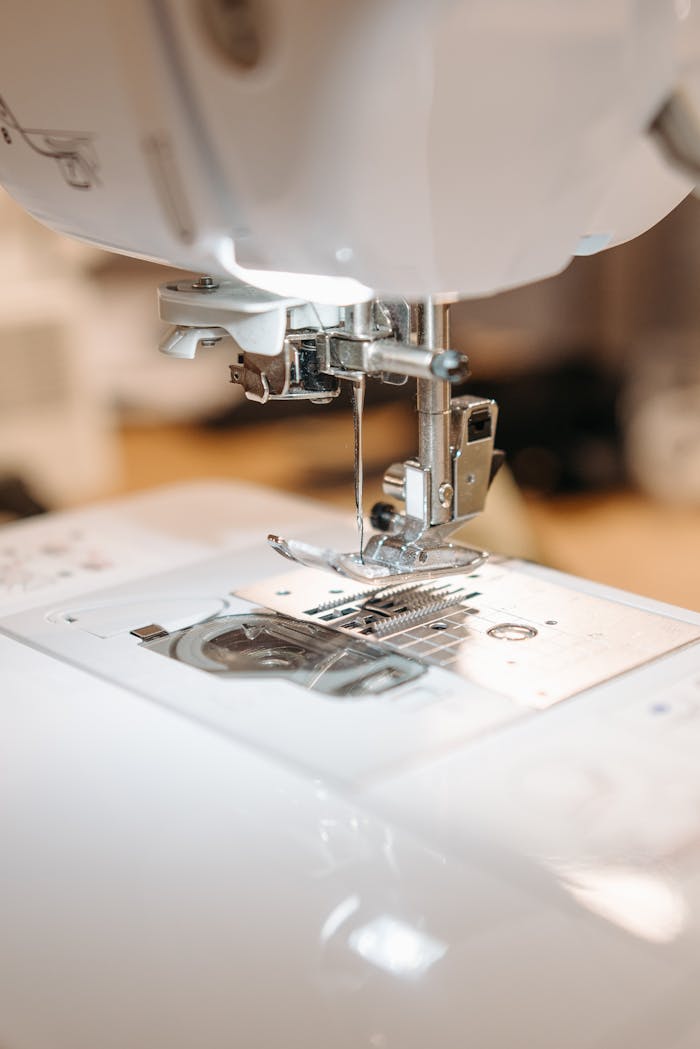 Detailed view of a sewing machine needle ready for stitching fabric with precision.
