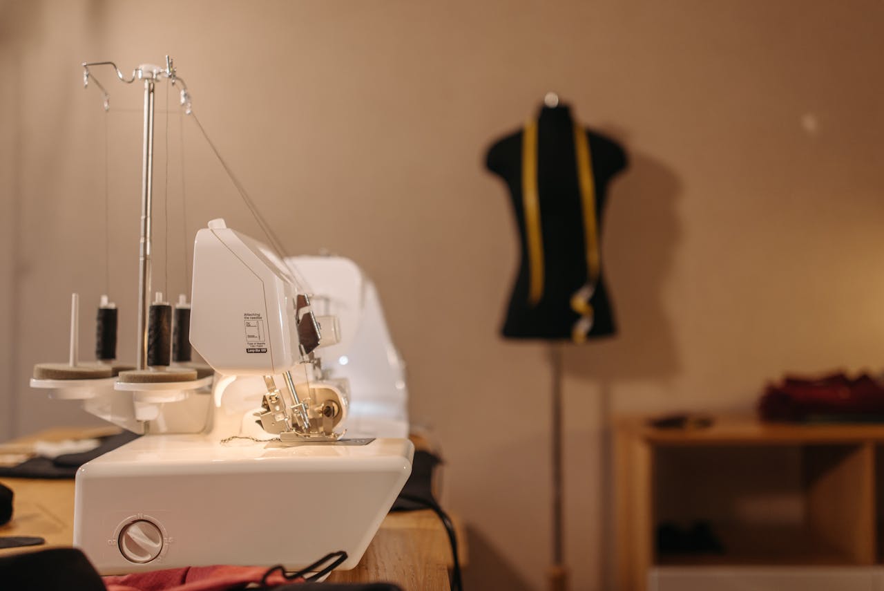 A sewing machine and tailor's manikin in a chic, organized atelier setting.