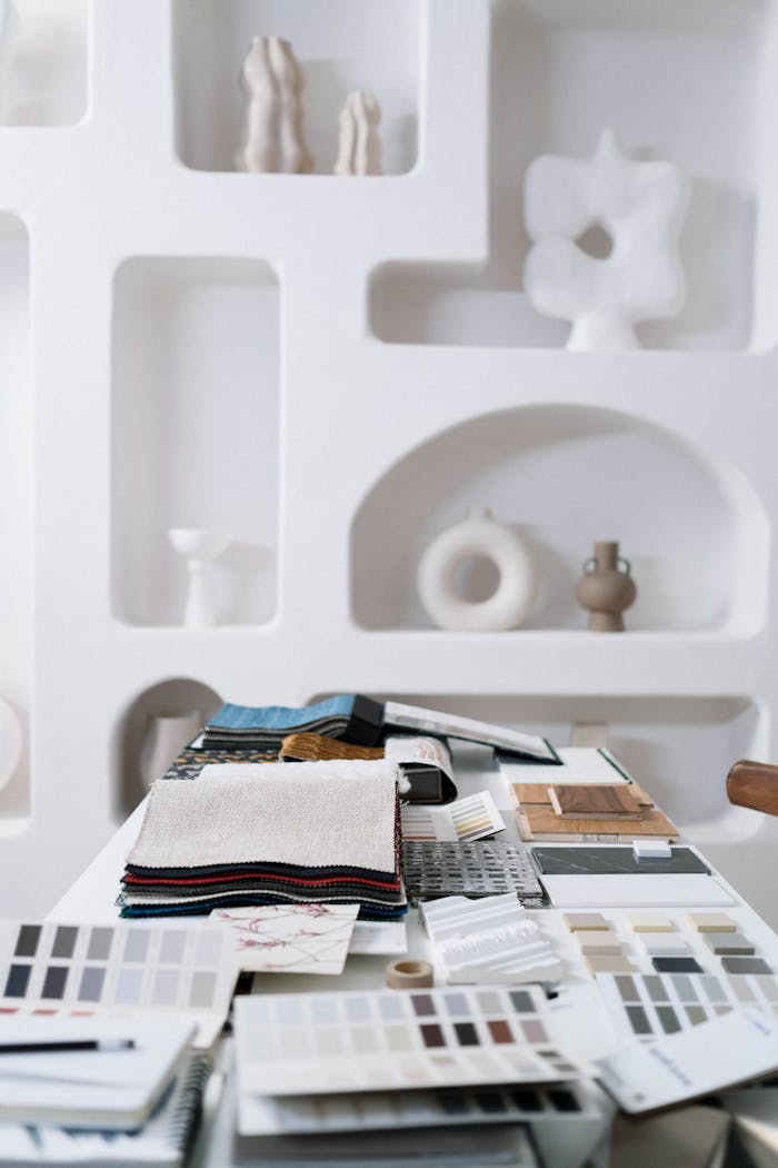 A thoughtfully curated space featuring art pieces and interior design samples on a table, highlighting modern aesthetics.