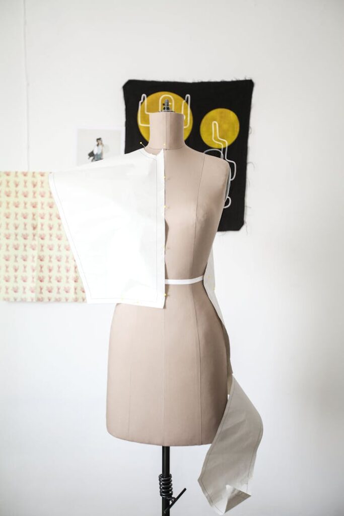 pexels photo 8030149 Female mannequin draped with white fabric in a fashion design studio, highlighting dressmaking process.
